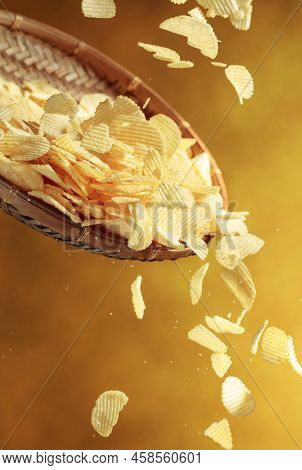 Falling Potato Chips On A Yellow Background. Copy Space.
