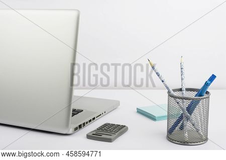 Lap Top, Case With Pencils And Markers, Calculator And Sticky Notes Placed On Desk. Computer, Colore