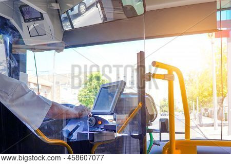 Hands Of Driver In A Modern Bus By Driving. Close-up Of Bus Driver Steering Wheel And Driving Passen