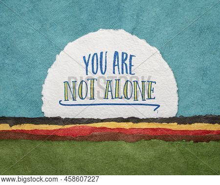 You Are Not Alone  - Inspirational Reminder, Handwriting On A Circular Sheet Of Watercolor Paper Aga