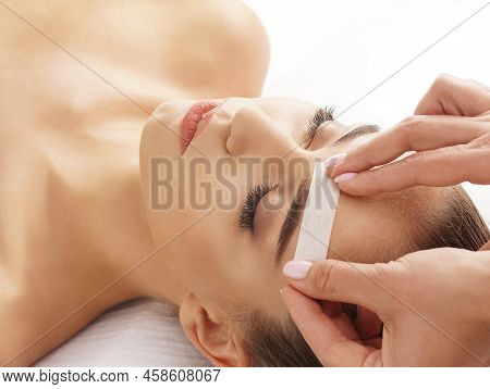 Beautician Is Removing Hair From Beautiful Female Face With Hot Wax. Woman Has A Beauty Treament Pro