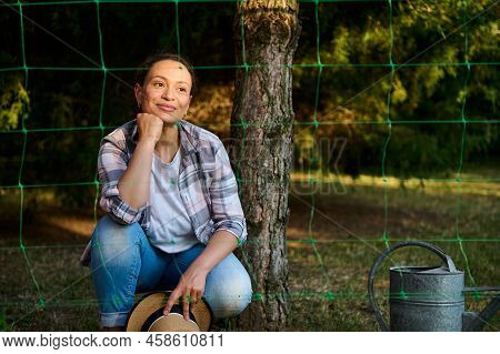 Charming Dreamy Hispanic Woman Gardener Agronomist Smiling While Planting Seedlings In The Backyard 