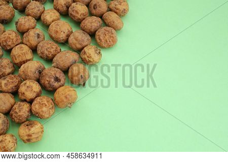 Top View Of Chufa, Tigernut, Earth Almond On Green Background With Copy Space For Text. Healthy Orga