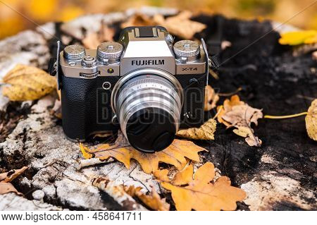 A New Fujifilm Xt4 Camera Are On An Old Log Among Yellow Autumn Leaves - Minsk, Belarus - October 10
