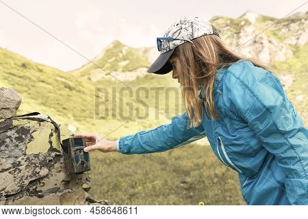 Young Woman Scientist Ecologist Zoologist Setting Up A Trap Camera In A Nature Reserve In The Mounta