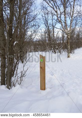 Rustic Trail Indicator Post In Snowy Landscape On The Polar Circle. Solid Wooden Post In The Middle 