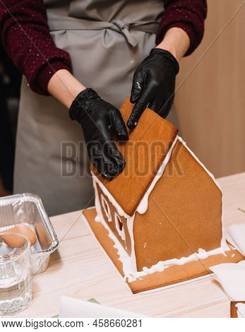 The Process Of Making A Gingerbread House, Gluing The Ginger Roof With Icing, Squeezing Tight