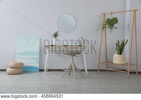 Stylish Room Interior With Round Mirror On Wall Over Console Table