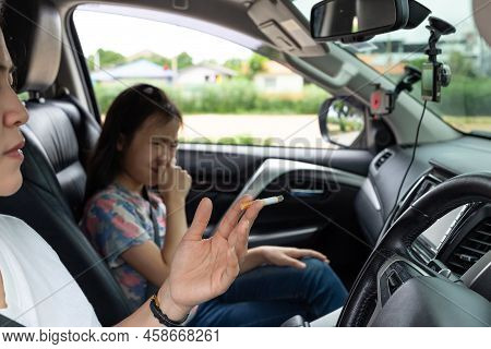 Asian Woman Smoking Cigarette While Driving Inside The Car And The Child Choking Of Smoke,stop Smoki