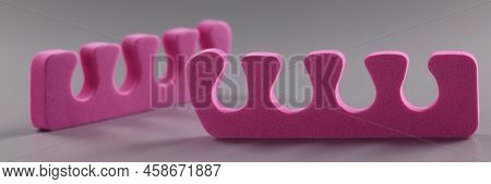 Pink Toe Divider On Gray Background. Pedicure Accessory Concept