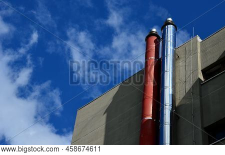 Industrial White Building With Sheet Metal Facade Of Repeating Rectangle Paneling. On Wall Are Two S
