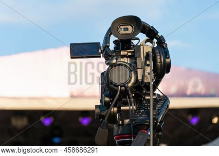 Professional Digital Video Camera Shoots Video Outdoors On A Sunny Day, Rear View