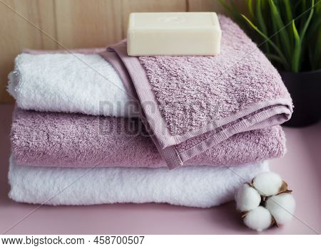 Stack Of White And Pink Towels With A Piece Of Soap