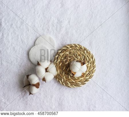Cotton Pads With Cotton Flower Laying On The White Towel