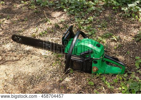 Hand Gasoline Chainsaw Lies On The Ground