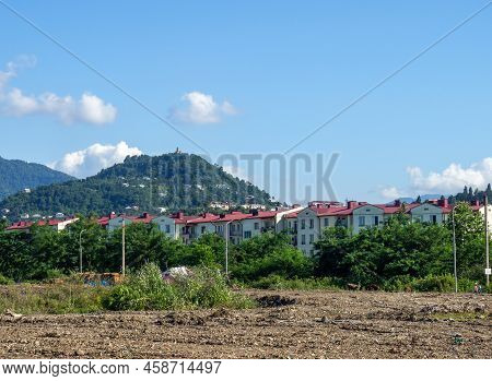 Houses Against The Backdrop Of The Mountains. Sameba Monastery. Cityscape Of Georgia. Old Houses