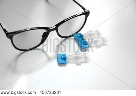 Single Dose Eye Drops And Glasses On White Table