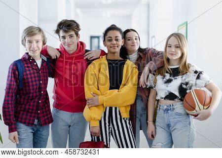 Young High School Students Walking In Corridor And Looking At Camera At School, Back To School Conce