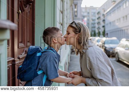 Mother Kissing Her Young Son On The Way To School, And A Mother And Boy Say Goodbye Before School, B