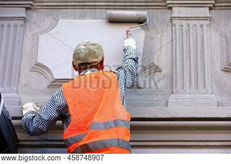 Worker Repair The Building Wall. Builder Painting The Facade, Construction And Repair Works