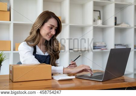Portrait Of Young Asian Woman Working Sme With A Box At Home The Workplace.start-up Small Business O