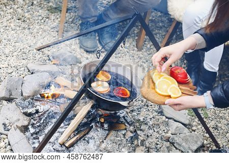 From Above Traditional Mulled Wine With Slices Of Orange Preparing In Pot Over Burning Logs In Winte