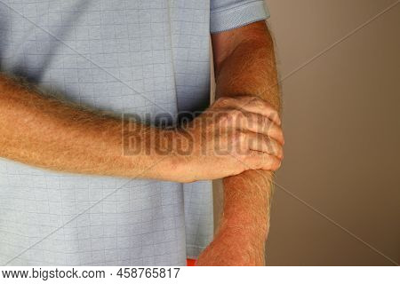 Front View Close-up Of A Mature Caucasian Male Massaging His Left Forearm With His Right Hand. Left 