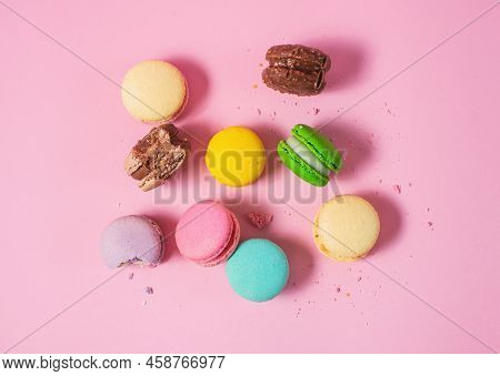 Bright Colorful Various Flavor Macarons Sweet Cookies On Pink Background.