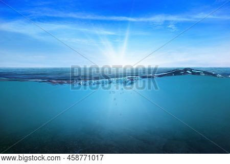 Blue Under Water Waves And Bubbles. Beautiful White Clouds On Blue Sky Over Calm Sea With Sunlight R