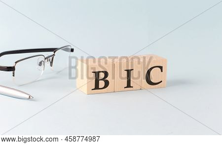 Wooden Cubes With The Word Bic Bank Identifier Code On A Financial Background With Chart, Calculator