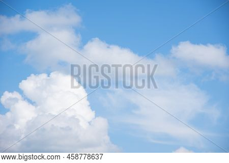 Blue Sky Background With White Fluffy Cumulus Clouds. Panorama Of White Fluffy Clouds In The Blue Sk