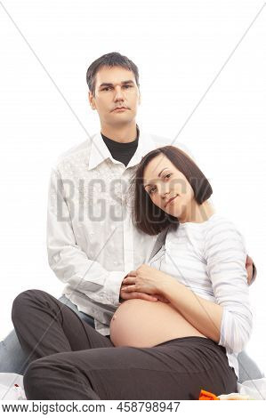 Happy Caucasian Family With Pregnant Whife And Caring Husband While Posing Together And Embracing Hi