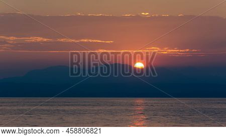 Sun Is Setting Behind Big Mountain At Garda Lake