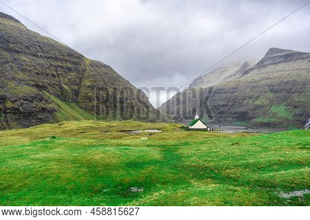 Beautiful Little Church, With A Grassy Roof, Against The Backdrop Of Beautiful Mountains, And Dramat