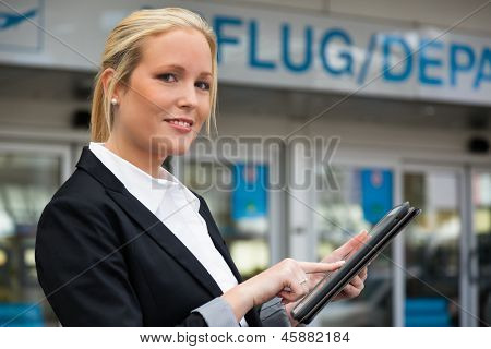 una donna d'affari utilizzando il suo computer tablet in un aeroporto. mobilità e comunicazione nel mondo degli affari. Roa
