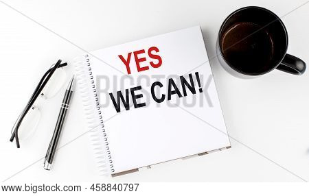 Coffee,glasses,pen And Notebook Written With Yes We Can , On White Background.