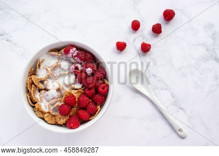 Bowl Of Multigrain Cereal With Yogurt And Fresh Raspberry Berries On Marble Table Background. Health