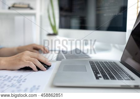 Professional development programmers are sit on a desk with work equipment such as: computer-laptop-
