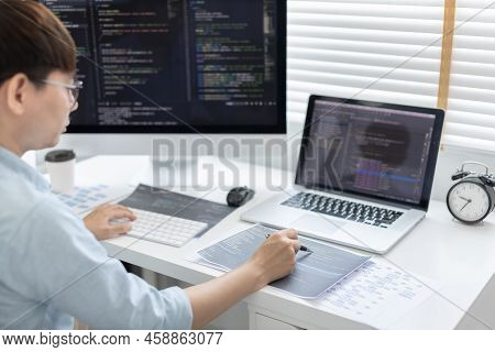Professional development programmers are laying out a structure or draft on paper in preparation for