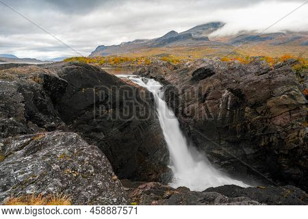 Mighty Scenic Waterfall Under Dramatic Sky. Stuor Muorkke Waterfall In Stora Sjofallet National Park