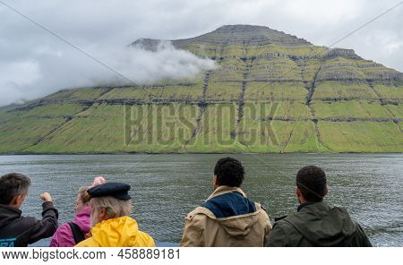 Kalsoy, Faroe Islands - 06.12.2017: People Aboard Small Boat Sailing Towards Kalsoy Insland On A Clo