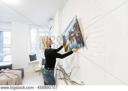 Canvas Print With Gallery Wrap. Woman Hangs Photography On White Wall. Hands Holding Photo Canvas Pr