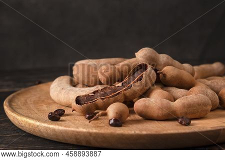 Fresh Tamarind Fruits (tamarindus Indica, Indian Date) Sweet Ripe Tamarinds On Dark Wood Background.