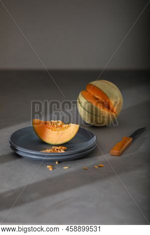 Slice Of Melon, Honey Melon On Gray Plate. Melon, Knife On Grey Background. Fruit. Healthy Food Conc
