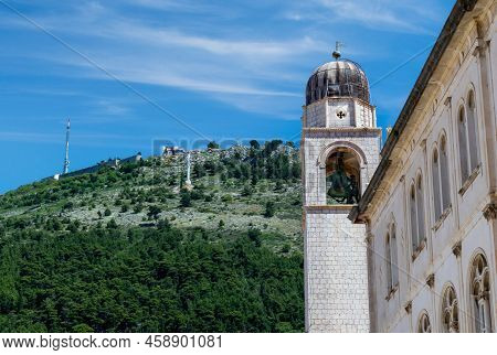 Mt. Srd Towers Over The Old Town Of Dubrovnik As Seen Against The Landmark Bell Tower