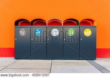 Garbage Bins Garbage Sorting. Near Bright Red Wall, Five Metal Containers For Various Garbage With A