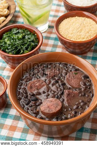 Typical Brazilian Feijoada With Rice, Caipirinha, Farofa And Cracklings.