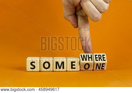 Someone Somewhere Symbol. Businessman Turns Wooden Cubes And Changes The Concept Word Someone To Som