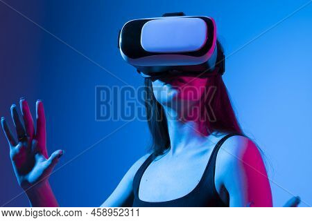 Young Woman Working In Vr Goggles On A Grey Background. Modern Architect Using Virtual Reality Glass