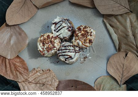 Two Cinnabon Chocobon (soft Chocolate Buns) Topped With Rich Cream Cheese Frosting And Two Caramel P